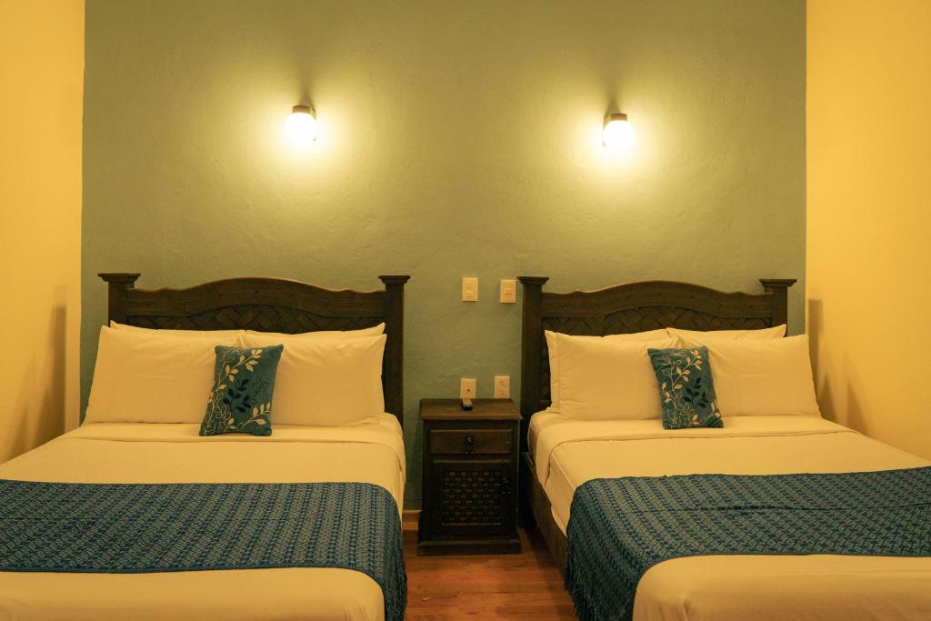 圣克里斯托瓦尔-德拉斯卡萨斯VO´E的酒店客房设有两张床和两盏灯。