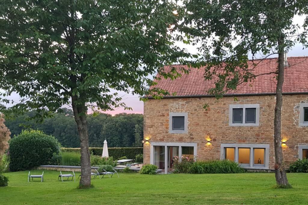HavelangeGite rural '21 bonnes raisons' - Ossogne的一座带草坪和树木的大型砖屋
