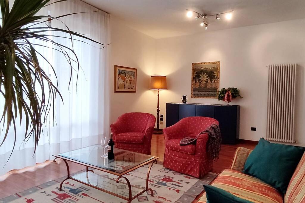 Castelfranco di SottoDiamante: Appartamento nel cuore della Toscana的客厅配有2把红色椅子和玻璃桌
