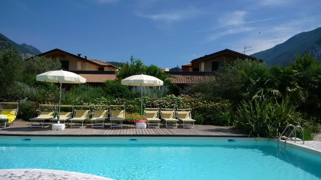 阿科Agritur Acquastilla Giovanni Poli的房屋旁的游泳池配有椅子和遮阳伞