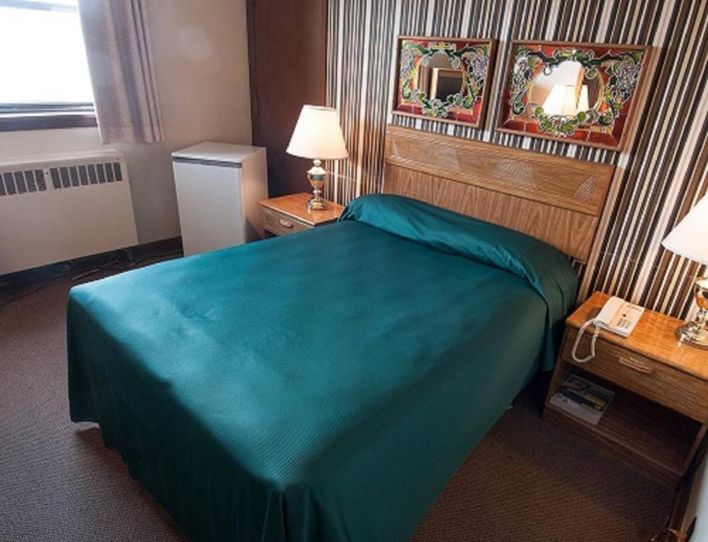 温尼伯柯蒂斯戈登汽车旅馆的酒店客房,配有一张带蓝色毯子的床