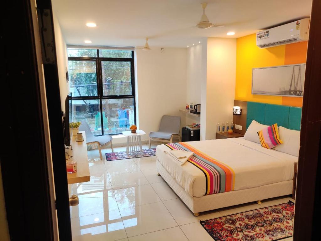 海得拉巴Hotel White Fields Hitec City, Hyderabad的一间卧室设有一张床和一间客厅。
