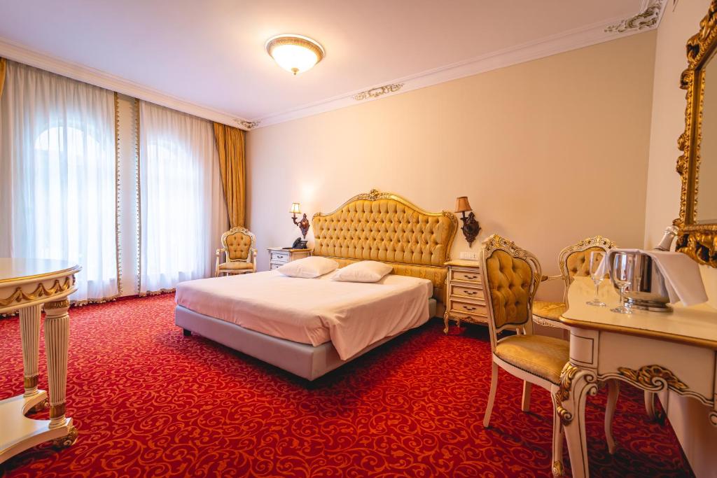 吉格涅斯科斐耶Casino & Hotel ADMIRAL Skofije的一间卧室配有一张特大号床和红地毯
