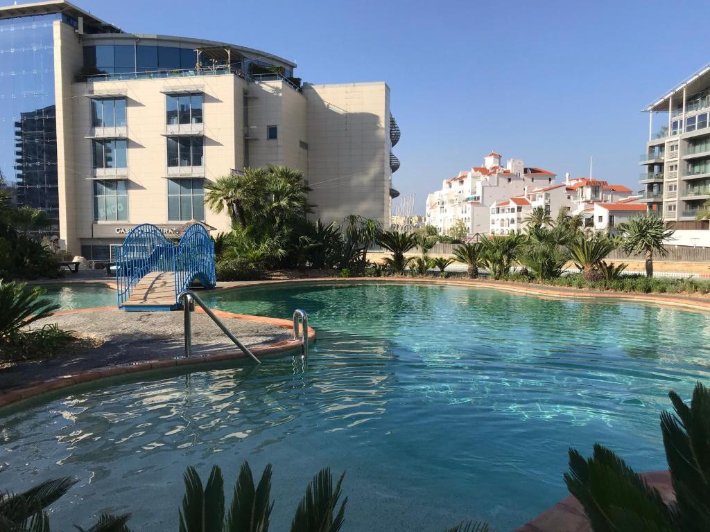 直布罗陀Swimming pools Apartment in Ocean Village - 2 bed 2 bath Rock view的大楼前带椅子的游泳池