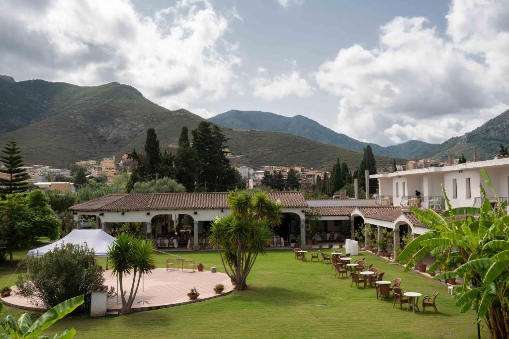 穆拉沃拉Hotel Domu Incantada的配有桌椅的度假村,以山脉为背景
