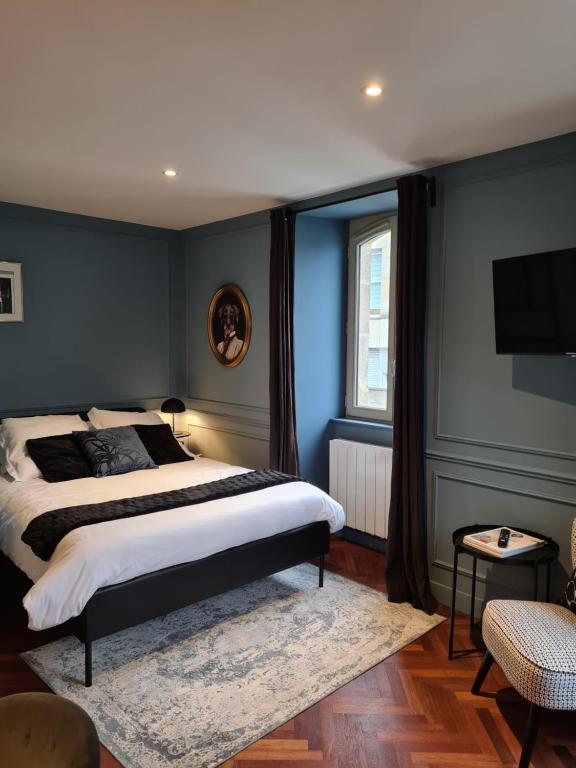 瓦讷LESAGE, au coeur de Vannes的一间拥有蓝色墙壁的卧室和一张铺有地毯的床