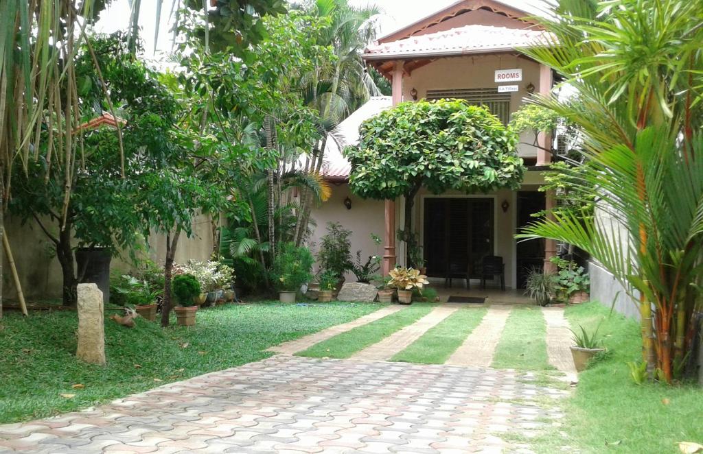 丹不拉SA村庄旅馆的一座带花园和砖砌走道的房子