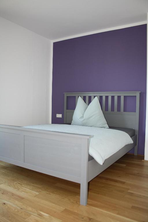 因斯布鲁克Felseck Zimmer的一间卧室配有一张紫色墙壁的床