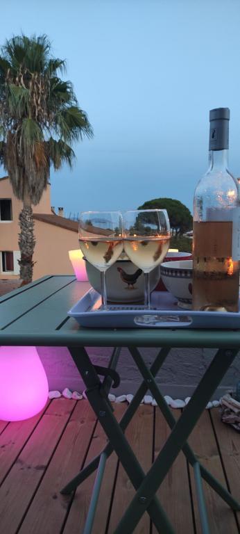耶尔Suite avec tropezienne vue mer的一张桌子,上面放着两杯酒和一瓶葡萄酒