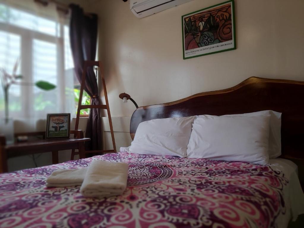 马那瓜Casa Benjamin Linder的一间卧室配有一张床,上面有两条毛巾