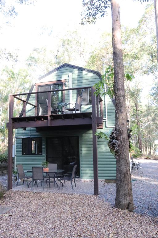 LandsboroughGREEN TREES CHALET 10 minutes to Australia Zoo Landsborough Montville Maleny Caloundra Beaches Glasshouse mountains Big Kart Track National forest的房屋设有1个带桌椅的甲板