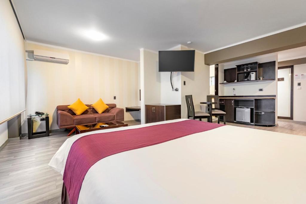 利马Hotel Andesmar的酒店客房设有一张大床和一间客厅。
