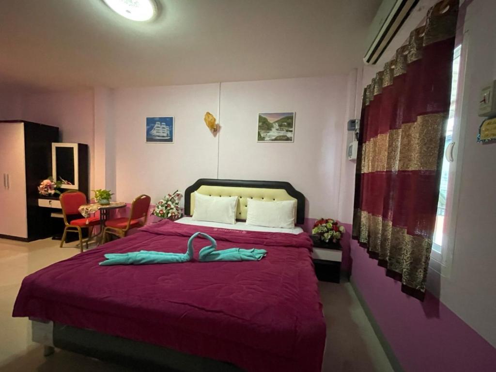 北碧Diamond Resort的一间卧室配有一张大床和紫色毯子