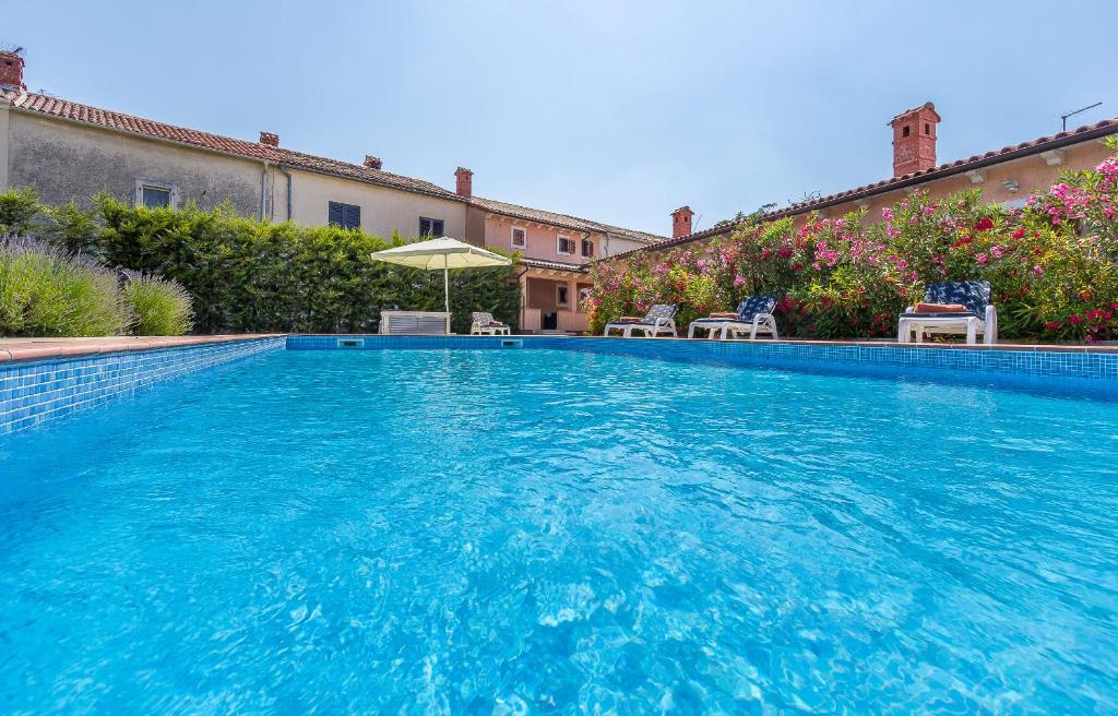 罗波里卡Pool & Sun Villa Rici的一个带椅子和遮阳伞的大型蓝色游泳池