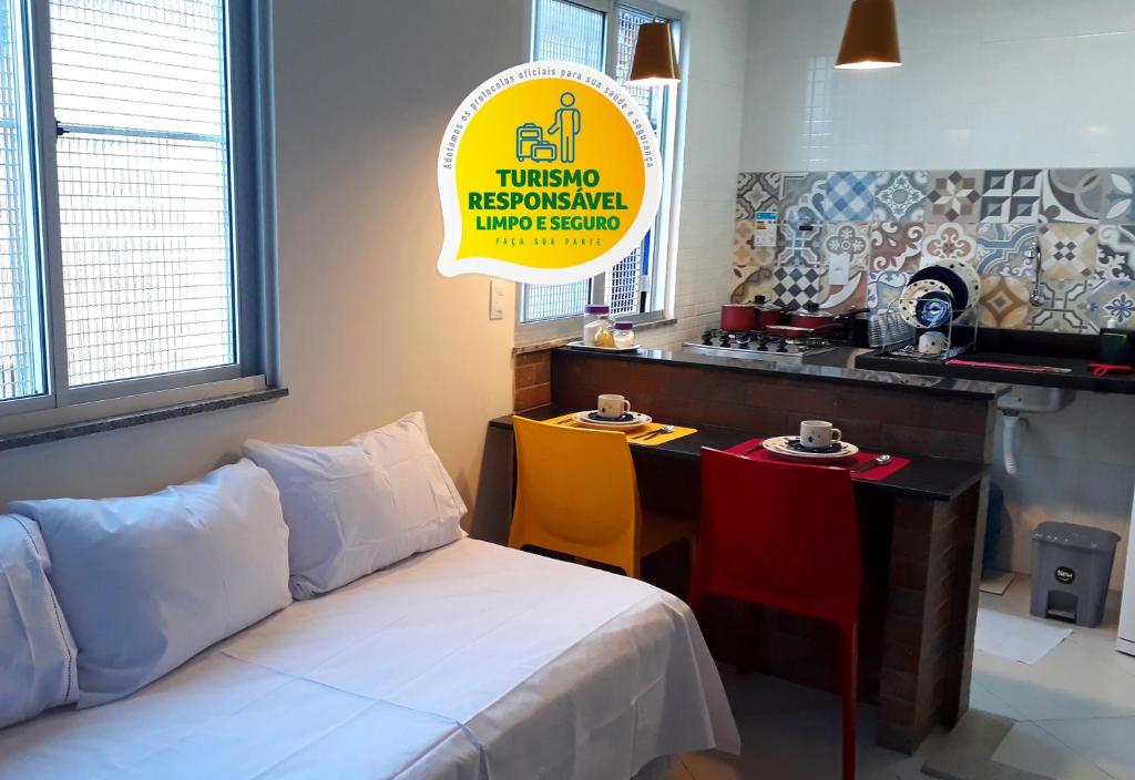 萨尔瓦多Hart Aparthotel Ltda的配有床和桌子的房间以及厨房