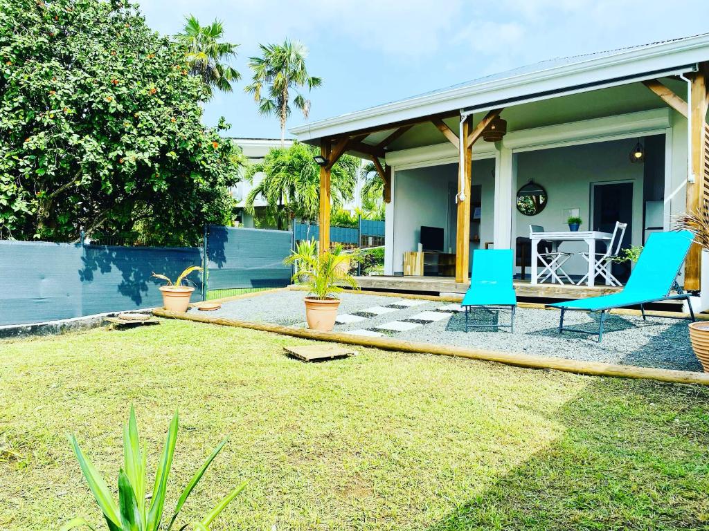 哥西尔Vanille, à proximité des plages, idéalement situé pour visiter la Guadeloupe的庭院内带蓝色椅子的庭院