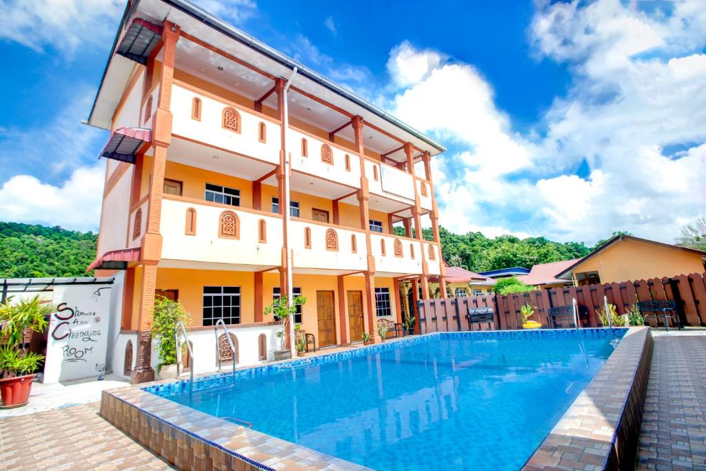 珍南海滩NR Langkawi Motel的大楼前设有游泳池的酒店