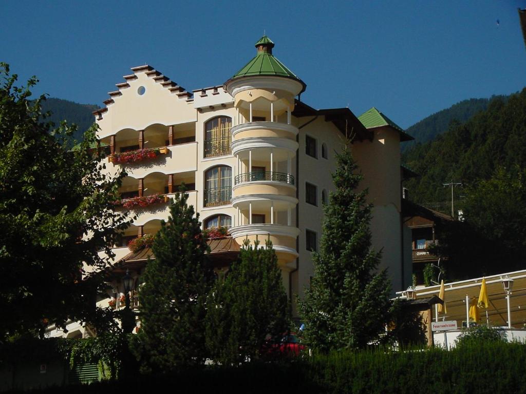 迈尔霍芬Hotel Sieghard Zillertal的一座白色的大建筑,设有绿色屋顶