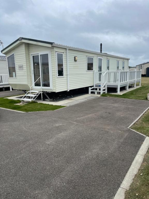 斯凯格内斯Golden Palm Chapel St Leonards 8 Berth 3 Bedroom Caravan的白色移动房屋 - 带门廊和车道