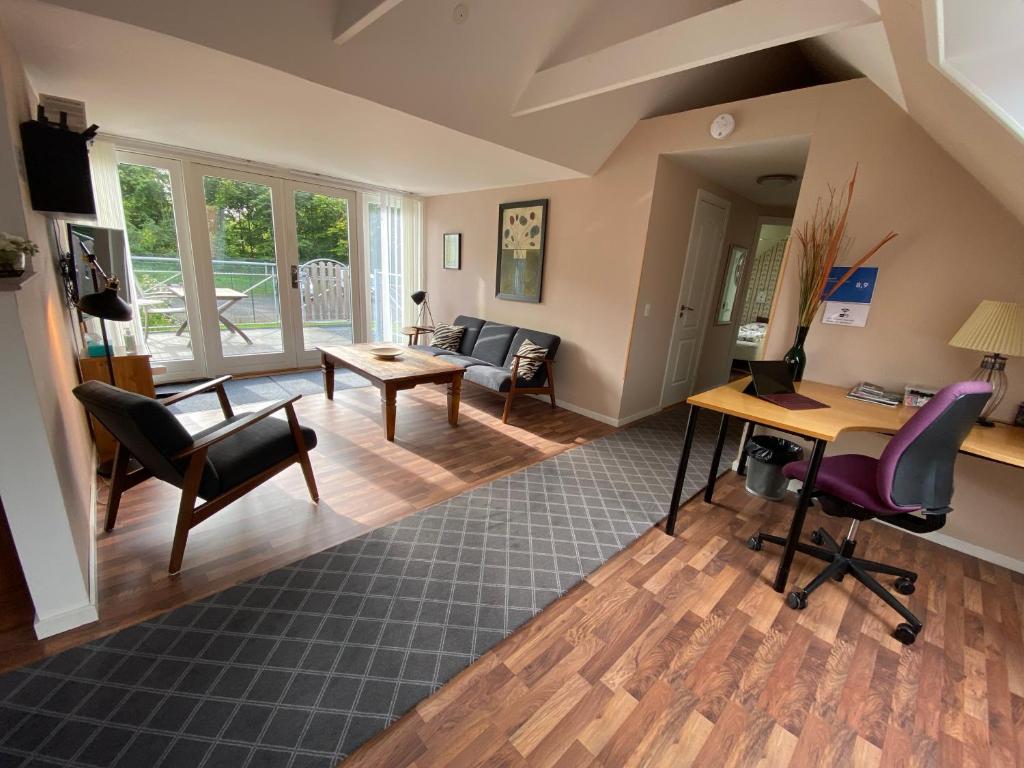 罗斯基勒Country flat的开放式客厅配有桌子和椅子