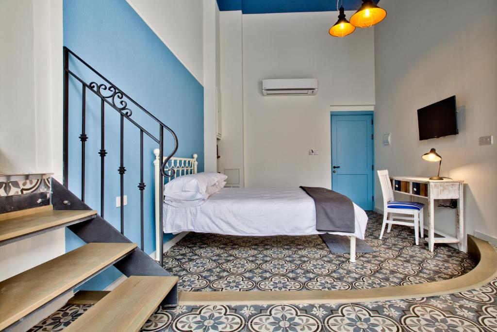 瓦莱塔Chateau La Vallette - Grand Master's Suite的一间卧室配有一张床、一张书桌和一个楼梯