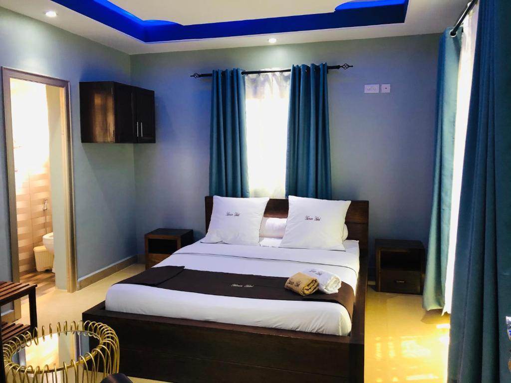 塔那那利佛Human hotel Ivato的一间卧室配有一张蓝色墙壁和蓝色窗帘的床