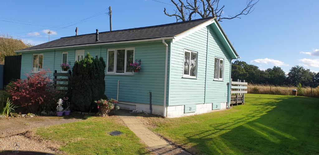贝克尔斯The Cabin,Kings Lane,Weston的一座带草地庭院的蓝色小房子