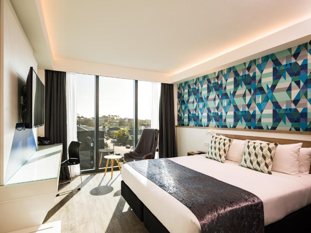 基督城Carnmore Hotel Christchurch的酒店客房设有一张床和一个大窗户