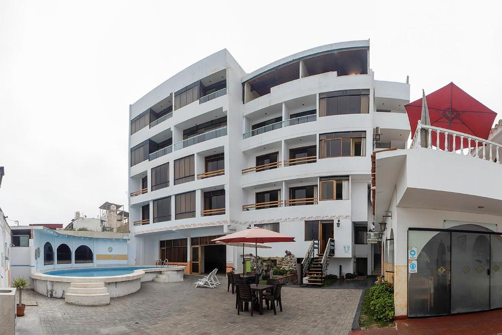 万查科Hotel Huankarute的一座大型白色建筑,旁边设有游泳池