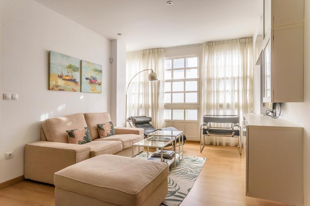拉科鲁尼亚Precioso apartamento nuevo en el centro de A Coruña!的客厅配有沙发和桌子