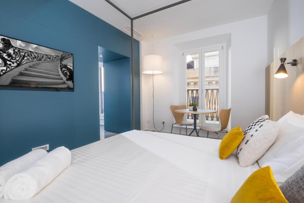 罗马Camplus Hotel Roma Centro的一间卧室配有一张白色大床和蓝色的墙壁
