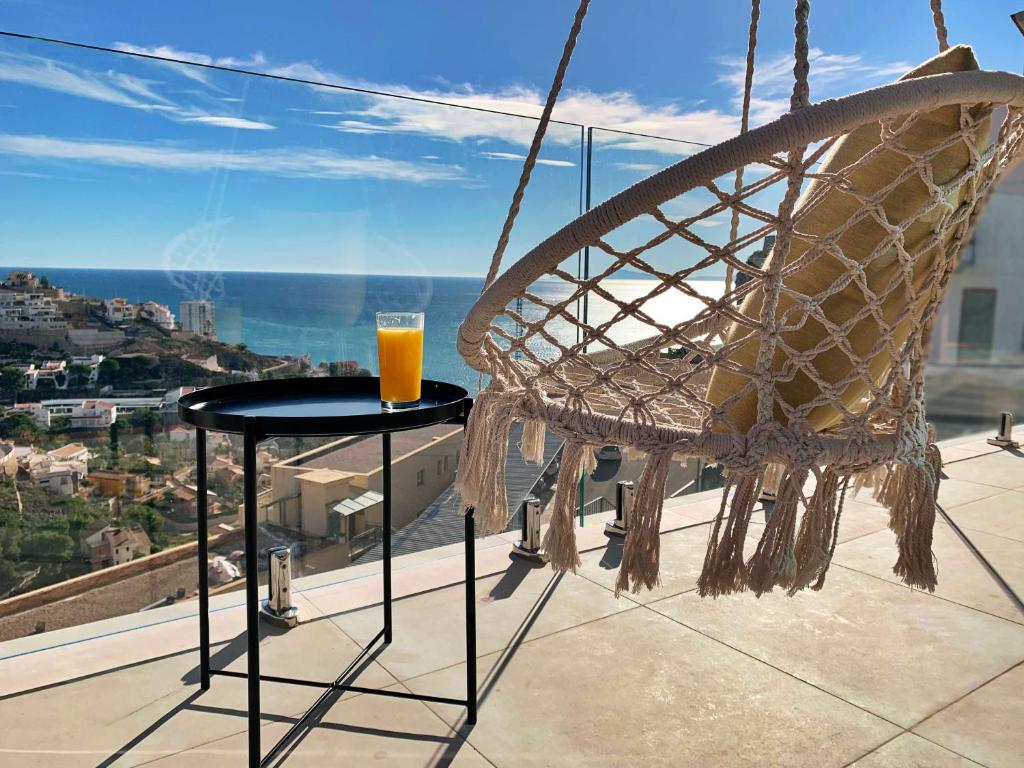 库列拉Colina del Sol Cullera - Villa Luna的坐在阳台上的桌子上喝一杯橙汁