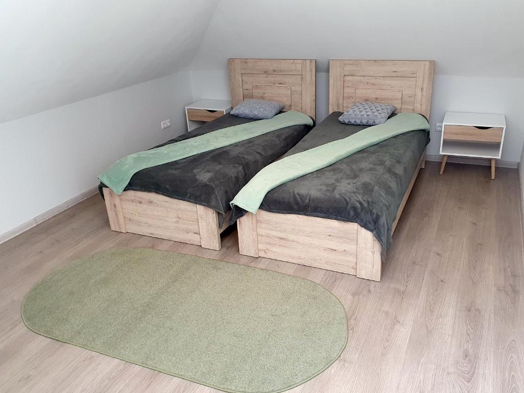 AkmenėKambarių nuoma - Pašakarniai SAURIDA的配有两张单人床的客房,设有2个地毯