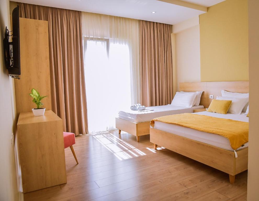 RinasAirport Garden Hotel的酒店客房设有两张床和窗户。