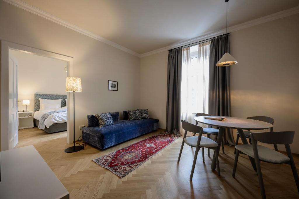 布鲁尼科Hotel Bruneck Design-Apartments的客厅配有蓝色的沙发和桌子