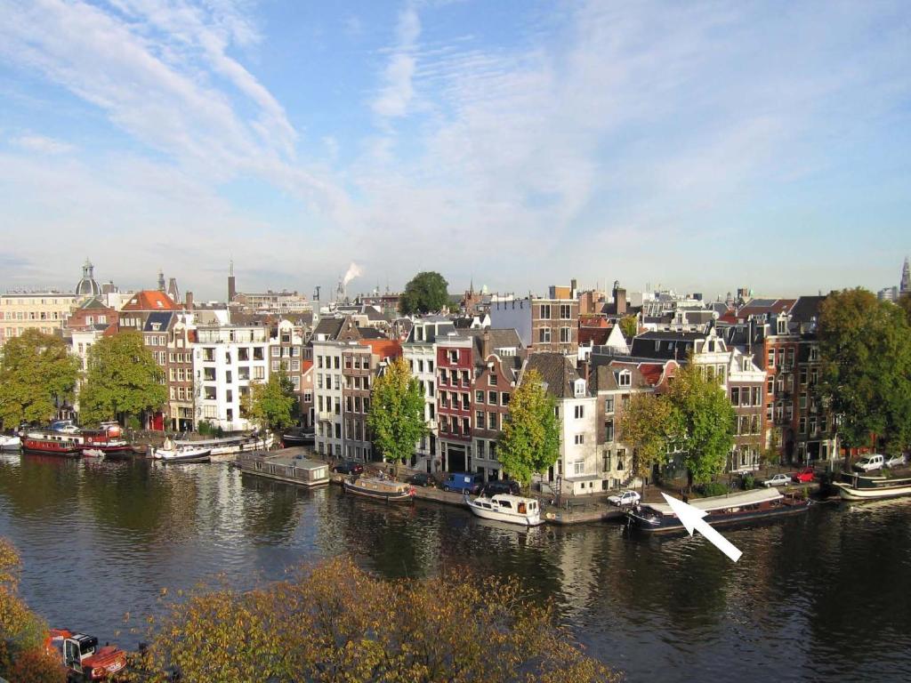 阿姆斯特丹阿姆斯特丹运河酒店的享有河流和建筑的城市美景