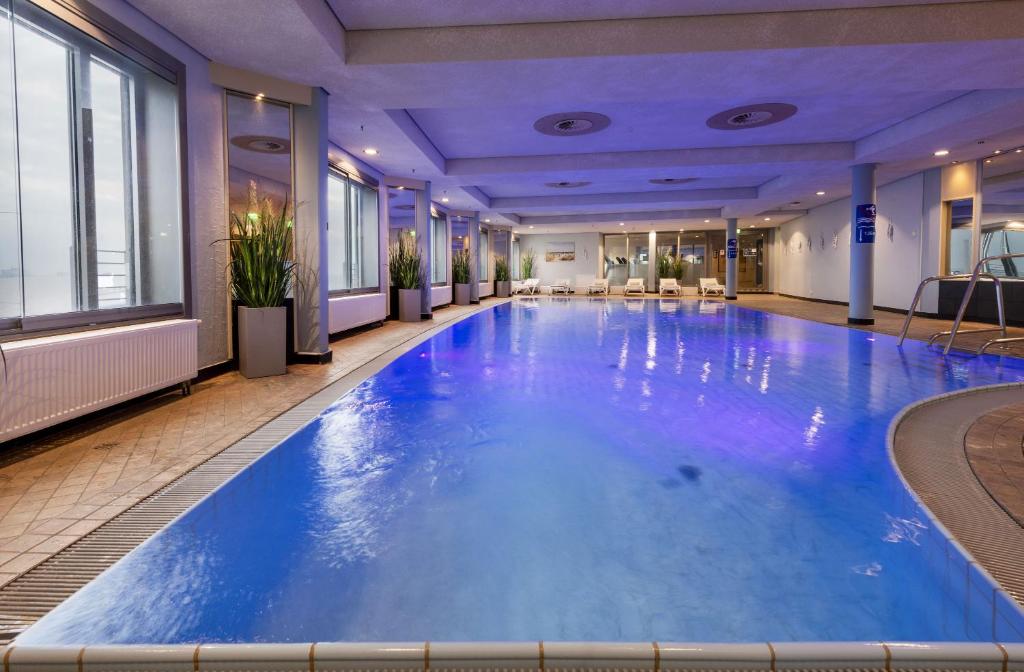 美因河畔法兰克福玛丽蒂姆法兰克福酒店的蓝色的大游泳池,位于酒店客房内