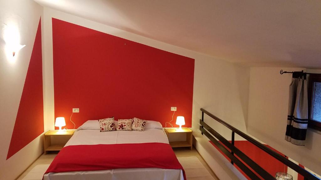 瓦雷泽Honeycomb - casa vacanze的卧室设有红色的墙壁和一张床