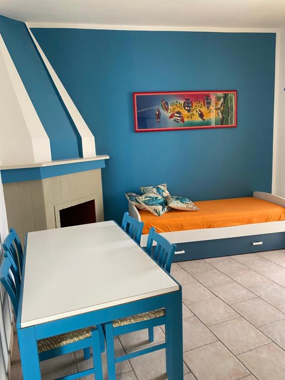 维拉诺瓦casa patrizia的配有一张床和一张桌子及椅子的房间