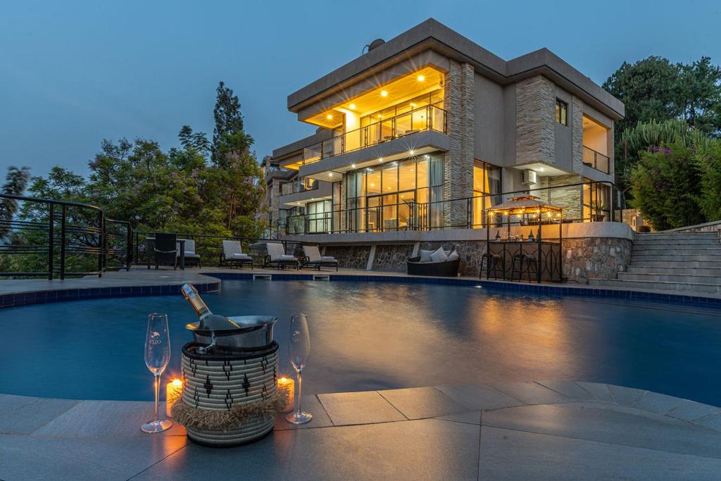 MwendoCLEO LAKE KIVU HOTEL的一座房子,设有一座带两杯酒杯的游泳池
