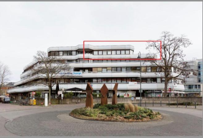 勒沃库森1 Person - Single - Appartement -Zentral gelegen in Leverkusen Wiesdorf - Friedrich Ebert Platz 5a , 4te Etage mit Aufzug-und mit Balkon的一座大建筑,前面有雕像