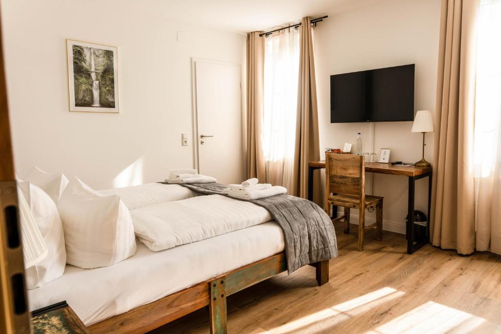 加格瑙RISA Hotel Village - Engel & Kreuz的一间卧室配有一张带书桌和电视的床。