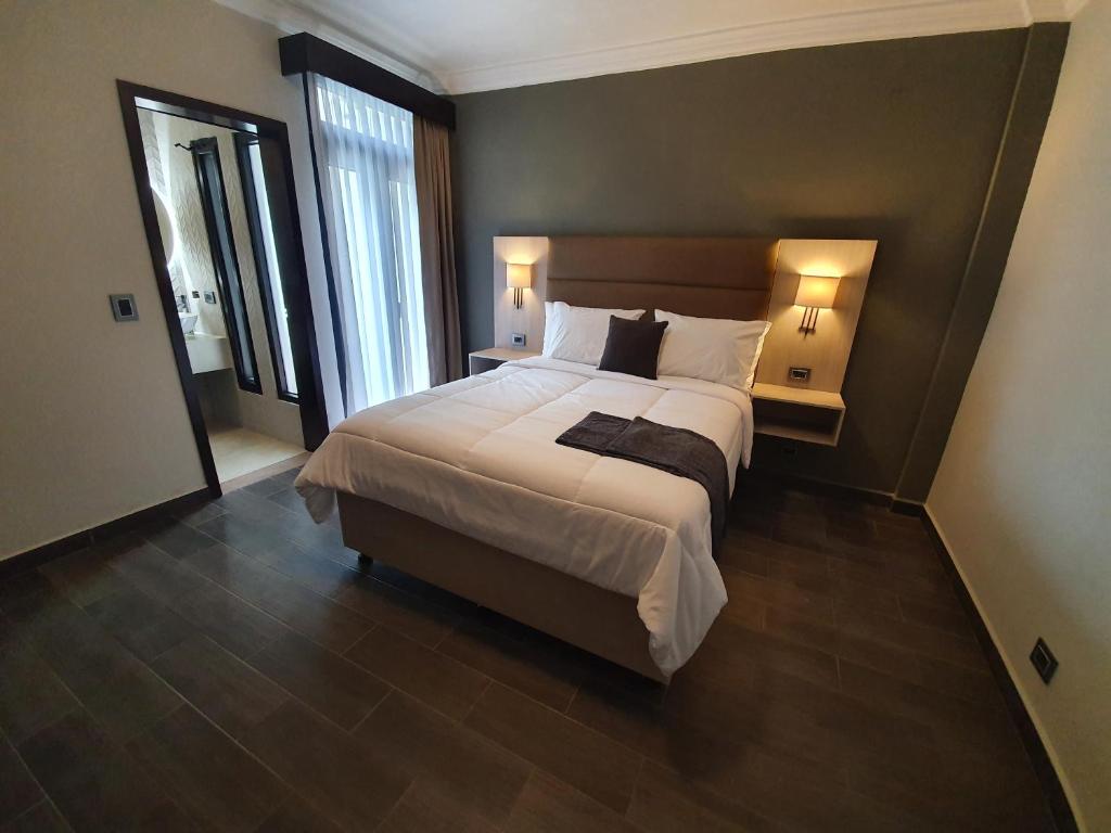 危地马拉L'Aurora Inn的一间卧室配有一张大床和两盏灯。