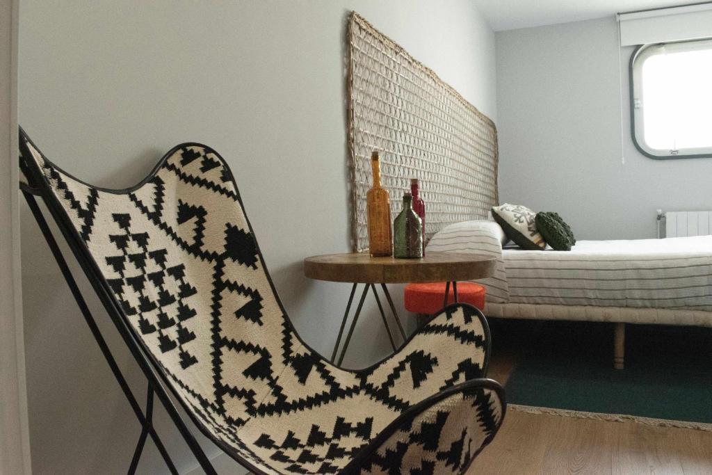 奥伦塞Apartamento Dúplex Estación Manzaneda的一间带椅子和一张桌子及一张床的房间