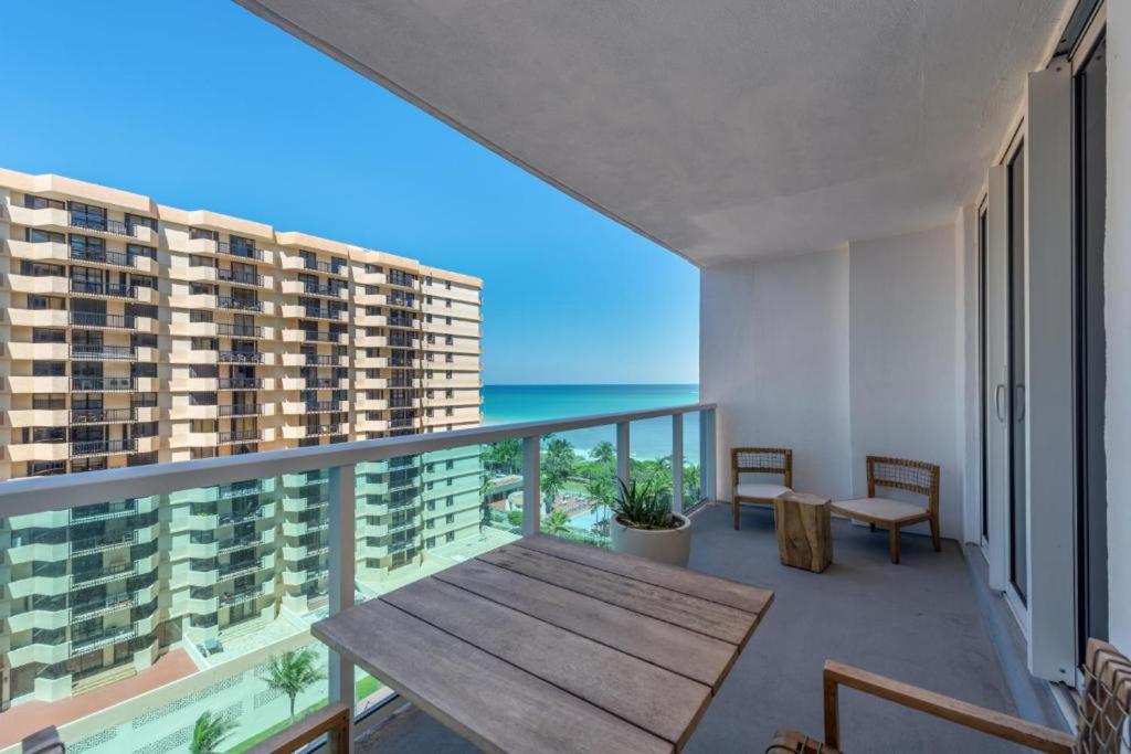 迈阿密海滩1 Hotel & Homes Miami Beach Oceanfront Residence Suites By Joe Semary的阳台设有木桌,享有海景。