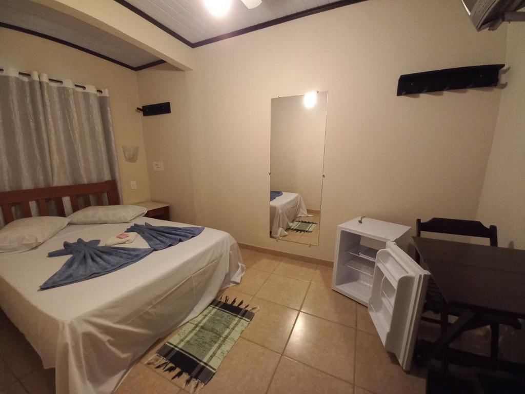 新弗里堡Pousada Girar do Sol的一间小卧室,配有两张床和镜子