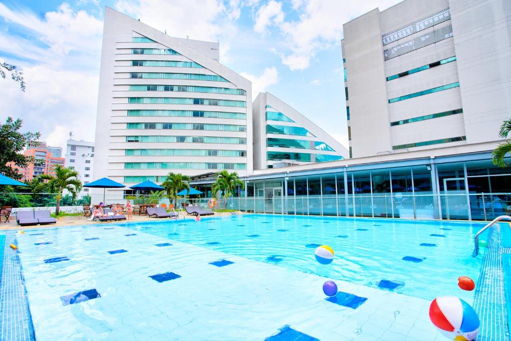 麦德林圣费尔南多广场酒店 的大楼前的大型游泳池