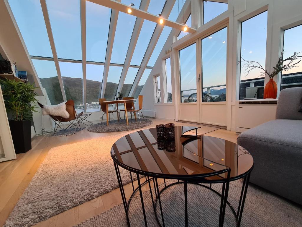 特罗姆瑟Glass roof private loft in Tromsø的客厅配有沙发和桌子