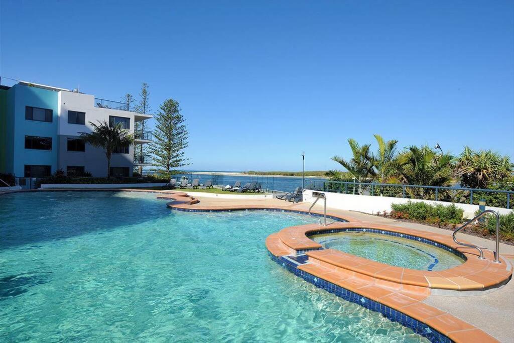 卡伦德拉Prime Position – Dream Holiday Unit in Caloundra!!的一座位于大楼旁的度假胜地的游泳池