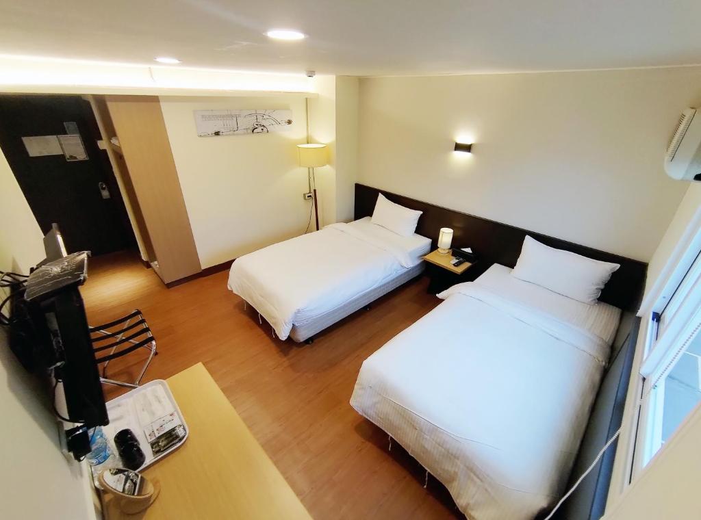 台东富裕商旅 RICH-hotel的酒店客房配有两张床和一张书桌